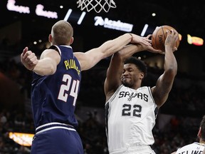 San Antonio Spurs forward Rudy Gay (22) grabs a rebound one Denver Nuggets forward Mason Plumlee (24) during the first half of an NBA basketball game, in San Antonio, Monday, March 4, 2019.