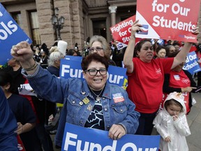 In this March 11, 2019, photo, Dr. Nancy Vera, center, of Corpus Christi, Texas, joins other educators during a rally to support funding for public schools in Texas at the state Capitol in Austin, Texas. Cost-cutting states are trying to keep schools happy as teacher unrest over low pay and overcrowded classrooms continues. But pressure from voters is forcing states to put more money on the table as much as much as picket lines.