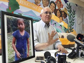 FILE - In this Dec. 15, 2018, file photo, Annunciation House director Ruben Garcia answers questions from the media after reading a statement from the family of Jakelin Caal Maquin, pictured at left, during a press briefing at Casa Vides in downtown El Paso, Texas. An autopsy has found that the 7-year-old girl from Guatemala who was detained by the U.S. Border Patrol died of a bacterial infection. Jakelin died on Dec. 8, just over a day after she was apprehended by Border Patrol agents with her father.
