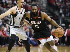 Houston Rockets guard James Harden (13) dribbles past San Antonio Spurs guard Derrick White during the second half of an NBA basketball game Friday, March 22, 2019, in Houston. Houston won 111-105.