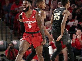 Houston guard Corey Davis Jr. (5) reacts to his three-point shot as he walks past Central Florida guard B.J. Taylor, middle, and guard Aubrey Dawkins (15) during the first half of an NCAA college basketball game Saturday, March 2, 2019, in Houston.