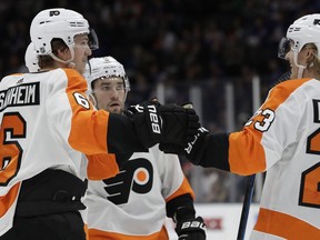 Philadelphia Flyers defenseman Travis Sanheim (6) celebrates with Flyers left wing Oskar Lindblom (23) as Flyers defenseman Robert Hagg, center, looks on after Sanheim scored the Flyers' second goal during the first period of an NHL hockey game, Sunday, March 3, 2019, in Uniondale, N.Y.