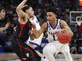 Northeastern guard Jordan Roland defends against Kansas guard Devon Dotson (11) in the first half during a first round men's college basketball game in the NCAA Tournament Thursday, March 21, 2019, in Salt Lake City.