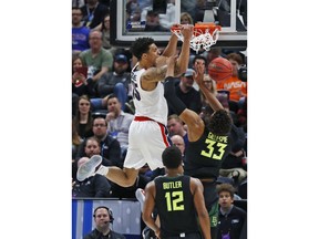 Gonzaga forward Brandon Clarke (15) dunks on Baylor's Freddie Gillespie (33) as Jared Butler (12) watches during the first half of a second-round game in the NCAA men's college basketball tournament Saturday, March 23, 2019, in Salt Lake City.