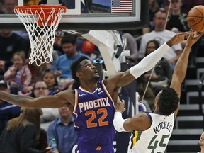 Phoenix Suns center Deandre Ayton (22) defends against Utah Jazz guard Donovan Mitchell (45) during the first half of an NBA basketball game Monday, March 25, 2019, in Salt Lake City.