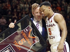 Virginia Tech coach Buzz Williams and senior guard Justin Robinson (5) hug during a ceremony honoring the team seniors, before the team's NCAA basketball game against Miami in Blacksburg, Va., Friday, March 8, 2019.