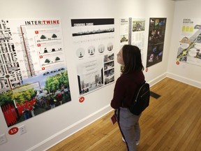 Valentine museum visitor, Kristi Mukk, of Richmond, looks over one of the proposals for changes to Confederate statues on Monument Avenue in Richmond, Va., Tuesday, Feb. 26, 2019. A new exhibit in Richmond showcases designs and ideas on what to do with Richmond's Confederate monuments. Local artists hope the exhibit will spark conversations about how to accurately document the city's history while not glorifying Confederate leaders.