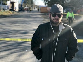John Newton, 28, is seen behind police tape in Maple Ridge, B.C., on Saturday, March 2, 2019. Newton says he was the last resident to leave the "Anita Place" homeless camp in Maple Ridge, B.C., when police and firefighters enforced an evacuation order Saturday and cordoned off the area.