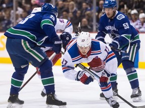New York Rangers' Jesper Fast (17) is upended by Vancouver Canucks' Alexander Edler (23), both of Sweden, during the first period of an NHL hockey game in Vancouver, on Wednesday March 13, 2019.