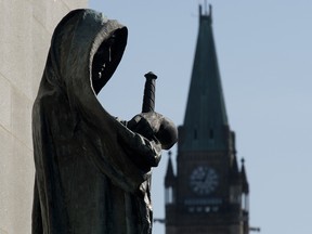 A statude of Veritas (Truth) guards the entrance of the Supreme Court of Canada as the Peace tower is seen in the background in a file photo from April 25, 2014, in Ottawa.
