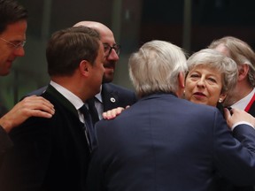 British Prime Minister Theresa May, right, speaks with European Commission President Jean-Claude Juncker, center, during a round table meeting at an EU summit in Brussels, Thursday, March 21, 2019. British Prime Minister Theresa May is trying to persuade European Union leaders to delay Brexit by up to three months, just eight days before Britain is scheduled to leave the bloc.