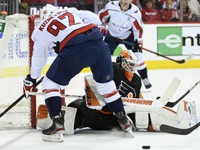 Philadelphia Flyers goaltender Brian Elliott (37) looks at the puck during the first period of an NHL hockey game against Washington Capitals center Evgeny Kuznetsov (92), of Russia, Sunday, March 24, 2019, in Washington.