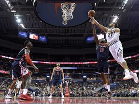 Denver Nuggets guard Jamal Murray (27) goes to the basket against Washington Wizards center Thomas Bryant (13), guard Tomas Satoransky (31) and forward Bobby Portis, left, during the second half of an NBA basketball game Thursday, March 21, 2019, in Washington. The Nuggets won 113-108.