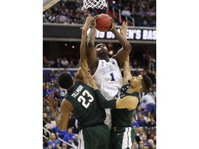 Duke forward Zion Williamson (1) drives under basket to score on on Michigan State forward Xavier Tillman (23) and forward Kenny Goins (25) during the second half of an NCAA men's East Regional final college basketball game in Washington, Sunday, March 31, 2019.