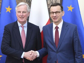 European Union Brexit negotiator Michel Barnier,left, and Poland's Prime Minister Mateusz Morawiecki, right, shake hands during a news conference following their talks on possible scenarios for Britain's departure from the 28-member bloc in Warsaw, Poland, Friday, March 29, 2019. Morawiecki said that if twice-rejected divorce deal is not approved Friday, the EU is open to Britain's requests for further extension of the departure process for up to 12 months.