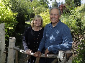 FILE - In this file photo taken July 23, 2018, Washington Gov. Jay Inslee poses for a photo with his wife, Trudi Inslee, on a path near their home on Bainbridge Island, Wash. Inslee is adding his name to the growing 2020 Democratic presidential field. The 68-year-old is announcing his bid Friday, March 1, 2019, in Seattle after recent travels to two of the four early-nominating states.