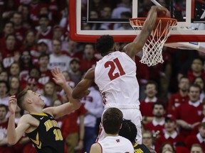 Wisconsin's Khalil Iverson (21) dunks past Iowa's Joe Wieskamp (10) during the first half of an NCAA college basketball game Thursday, March 7, 2019, in Madison, Wis.