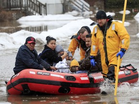Green Bay firefighters assist residents in evacuating their homes due to the East river flooding on Friday, March 15, 2019 in Green Bay, Wis. Heavy rain falling atop deeply frozen ground has prompted evacuations along swollen rivers in Wisconsin, Nebraska and other Midwestern states, while powerful wind and snow has impacted hundreds of miles of interstates in North Dakota.