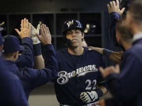 Milwaukee Brewers' Christian Yelich is congratulated after hitting a home run during the first inning of a baseball game against the St. Louis Cardinals Saturday, March 30, 2019, in Milwaukee.