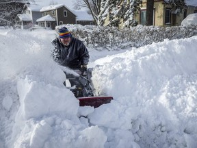 Pat Lundquist works at clearing the sidewalk all the way to the street Sunday, Feb. 24, 2019, near his house in Rochester, Minn., after heavy snow overnight.