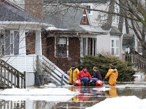 Green Bay firefighters assist residents in evacuating their homes due to floodwaters in Green Bay, Wis.