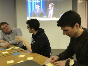 James Tabor, right, and other Tech For U.K. volunteers discuss ideas for anti-Brexit digital products in London, Thursday March 14, 2019. Members of Tech For U.K., a grassroots group of people working in Britain's tech industry, are using their tech skills to build online tools to help battle Brexit.