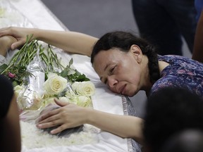 A relative mourns 15-year-old Caio Oliveira, a victim of a mass shooting at the Raul Brasil State School, in Suzano, Brazil, Thursday, March 14, 2019. Classmates, friends and families began saying goodbye on Thursday, with thousands attending a wake in the Sao Paulo suburb while authorities worked to understand what drove two former students to attack the school with a gun, crossbows and small axes.