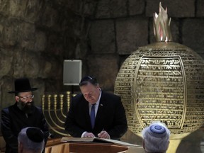 U.S. Secretary of State Mike Pompeo signs a guest book during a visit together with Israeli Prime Minister Benjamin Netanyahu and U.S. Ambassador to Israel David Friedman to the Western Wall Tunnels in Jerusalem's Old City, Thursday, March 21, 2019.