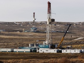 FILE- In this March 5, 2013, file photo, Trinidad Drilling rigs are seen off of Way Highway 59 outside of Douglas, Wyo. A judge has blocked oil and gas drilling on almost 500 square miles in Wyoming and says the government must consider cumulative climate change impacts of leasing public lands across the U.S. for energy development. The order marks the latest in a string of court rulings over the past decade faulting the government's consideration of emissions when issuing energy leases.