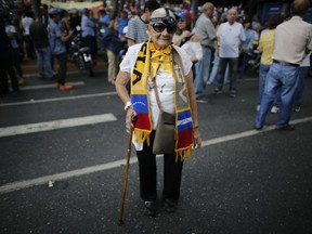 Trina Parry, 83, wearing a flash light over her head, joins a protest against the government of President Nicolas Maduro, as National Assembly President Juan Guaido visits points of protest in different areas of Caracas, Venezuela, Tuesday, March 12, 2019. Guaido has declared himself interim president and demands new elections, arguing that President Nicolas Maduro's re-election last year was invalid.