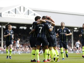 Manchester City players celebrate after Bernardo Silva scored the opening goal during the English Premier League soccer match between Fulham and Manchester City at Craven Cottage stadium in London, Saturday, March 30, 2019.