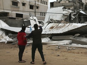 Palestinians inspect the damage of destroyed building belongs to Hamas ministry of prisoners hit by Israeli airstrikes in Gaza City, early Friday, Friday, March 15, 2019. Israeli warplanes attacked militant targets in the southern Gaza Strip early Friday in response to a rare rocket attack on the Israeli city of Tel Aviv, as the sides appeared to be hurtling toward a new round of violence.