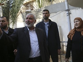 Hamas' supreme leader Ismail Haniyeh tours the site of a destroyed building, in Gaza City, Wednesday, March 27, 2019. Haniyeh made his first public appearance since a new round of cross-border violence with Israel this week. On Wednesday he visited the rubble of his Gaza City office, which was destroyed in an Israeli airstrike.