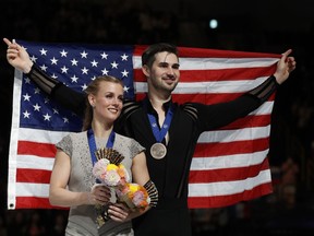 Gabriella Papadakis and Guillaume Cizeron of France, back to camera, hug Madison Hubbell and Zachary Donohue of the U.S. during the medal ceremony for the ice dance free dance during the ISU World Figure Skating Championships at Saitama Super Arena in Saitama, north of Tokyo, Saturday, March 23, 2019.