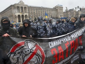 Far-right demonstrators carry a large banner reading "Poroshenko's pigs to jail" during a rally against corruption in Kiev, Ukraine, Saturday, March 16, 2019.