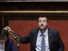 Italian Interior Minister and Vice Premier Matteo Salvini looks up at the Italian Senate, in Rome, Wednesday, March 20, 2019. The Senate is scheduled to vote on whether to lift Parliamentary immunity on Salvini in order for him to be prosecuted by a special tribunal for government ministers for suspected abduction, illegal arrest and abuse of office when he refused to let rescued migrants who were not minors or ill off the Italian Coast Guard Diciotti ship last August. At left is Italian Minister of Public Administration Giulia Bongiorno.