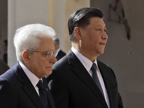 Chinese President Xi Jinping, right, and Italian President Sergio Mattarella review the honor guard at the Quirinale Presidential Palace, in Rome, Friday, March 22, 2019. Jinping is launching a two-day official visit aimed at deepening economic and cultural ties with Italy through an ambitious infrastructure building program called "Belt and Road" that has raised suspicions among Italy's U.S. and European allies.