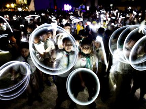 Philippine Boy Scouts play with their flashlights at the countdown for the 12th Earth Hour event Saturday, March 30, 2019 in suburban Makati city east of Manila, Philippines. Earth Hour is the symbolic switching off of the lights for one hour to help minimize fossil fuel consumption as well as mitigate the effects of climate change.