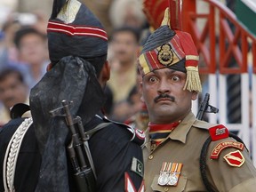 FILE - In this July 19, 2009, file photo, an Indian Border Security Force soldier, right, and a Pakistani Rangers soldier face one another at a daily closing ceremony at the Wagah border post near Lahore, Pakistan. A standoff with nuclear rival Pakistan appears to have given Indian Prime Minister Narendra Modi, the head of India's Hindu nationalist Bharatiya Janata Party-led government, a boost ahead of national elections set to begin in April, 2019.