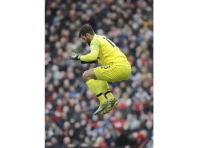 Liverpool goalkeeper Alisson Becker jumps during the English Premier League soccer match between Liverpool and Tottenham Hotspur at Anfield stadium in Liverpool, England, Sunday, March 31, 2019.