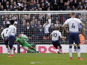 Tottenham's Harry Kane, second right, scores his side's opening goal from penalty during the English Premier League soccer match between Tottenham Hotspur and Arsenal at Wembley stadium in London, Saturday, March 2, 2019.