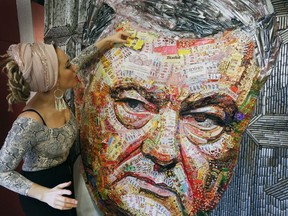 Ukrainian artist Dasha Marchenko adds a chocolate wrapper to her portrait of Ukraine's President and chocolate tycoon Petro Poroshenko at her studio in Kiev, Ukraine, Thursday, March 28, 2019. The artist bought around 20 kilograms of chocolate using the wrappers to create his face.  The framework was constructed using 4000 gun shells from battlefields in the country's east that has been hit by conflict with Russia-backed separatists since 2014. Poroshenko is running for the second term as president in elections to be held on March 31.