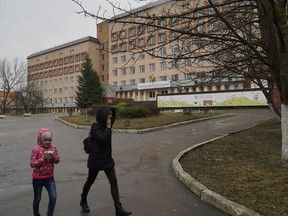 Mother and daughter walk away from the Rivne Regional Children's Hospital, in Rivne, Ukraine, on March 14, 2019.  As Ukrainians prepare to go to the polls in a presidential election March 31, millions of Ukrainians have already voted with their feet by leaving the country, seemingly mired in corruption, poverty and conflict.
