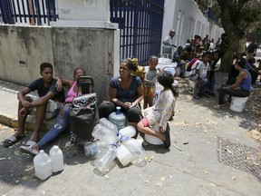 People wait their turn to fill containers with water from a public fountain in Caracas, Venezuela, Wednesday, March 13, 2019. Blackouts have marked another harsh blow to a country paralyzed by turmoil as the power struggle between Venezuelan President Nicolas Maduro and opposition leader Juan Guaido stretched into its second month.