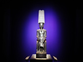 A status of "The god Amun protecting Tutankhamuns" is displayed as part of 'Tutankhamun, the treasure of the Pharaoh', an exhibition in partnership with the Grand Egyptian Museum at the Grande Halle of La Villette in Paris, France, Thursday, March 21, 2019.