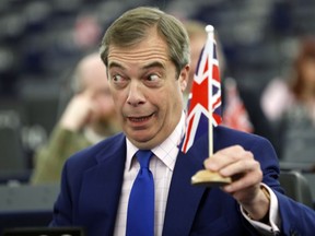 Former U.K. Independence Party (UKIP) leader and member of the European Parliament Nigel Farage holds a U.K. flag during a plenary session at the European Parliament in Strasbourg, eastern France, Wednesday, March 13, 2019. British lawmakers rejected May's Brexit deal in a 391-242 vote on Tuesday night. Parliament will vote Wednesday on whether to leave the EU without a deal.