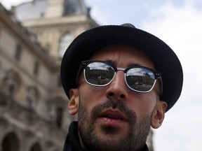 French street artist JR poses in the courtyard of the Louvre Museum near the glass pyramid designed by architect Leoh Ming Pei, in Paris, Wednesday, March 27, 2019 as the Louvre Museum celebrates the 30th anniversary of its glass pyramid. JR project is a giant collage of the pyramid to bring it out of the ground by revealing the foundations of the Napoleon courtyard where it is erected.