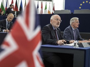 European Union's Frans Timmermans, first vice president of the Commission, center left, and European Union's chief Brexit negotiator Michel Barnier, right, attend a session at the European Parliament in Strasbourg, eastern France, Wednesday, March 13, 2019. British lawmakers rejected May's Brexit deal in a 391-242 vote on Tuesday night. Parliament will vote Wednesday on whether to leave the EU without a deal.