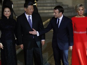 French President Emmanuel Macron, 2nd right, his wife Brigitte Macron, right, Chinese President President Xi Jinping, second left, and his wife Peng Liyuan, left, pose prior to a state dinner at the Elysee Palace in Paris, France, Monday, March 25, 2019. Chinese President Xi Jinping is on a 3-day state visit in France where he is expected to sign a series of bilateral and economic deals on energy, the food industry, transport and other sectors.