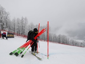 Poles marking the course are being taken out as a training session for a women's downhill race of the alpine ski World Cup, in Rosa Khutor, Russia, was cancelled due to adverse weather conditions Friday, March 1, 2019.